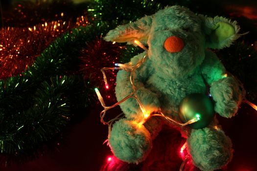 Teddy bear with Christmas tree balls, garlands and other colorful decorative elements