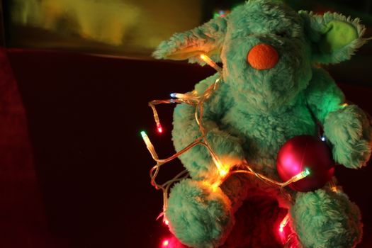 Teddy bear with Christmas tree balls, garlands and other colorful decorative elements