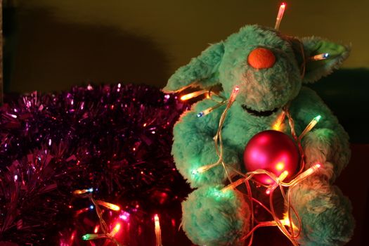 Teddy bear with Christmas tree balls, garlands and other colorful decorative elements