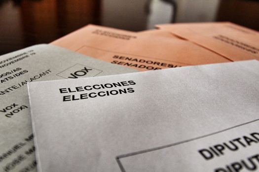 Ballots and envelops to vote on a wooden table at a polling station in Spain