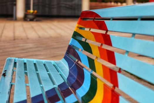 Bench in the city painted with the rainbow flag for gay pride celebration
