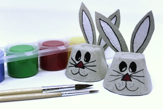 Easter bunnies made of cardboard egg cups and craft material. White background