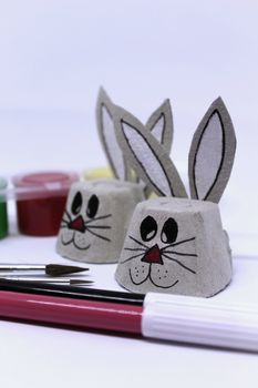 Easter bunnies made of cardboard egg cups and craft material. White background