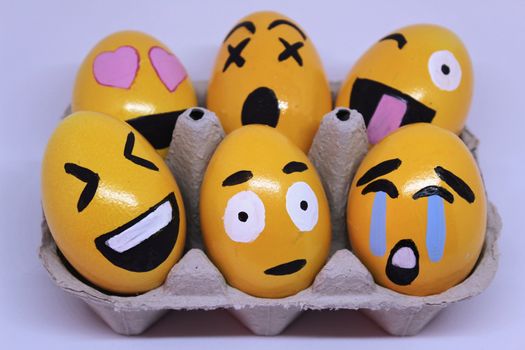 Emoticons Easter Eggs on egg-cup and white background.