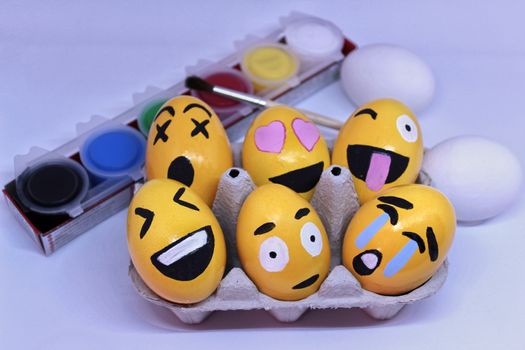 Emoticons Easter Eggs in egg-cup , paints and brush with white background