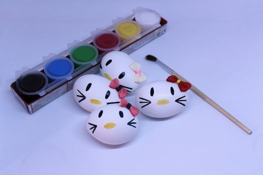 Kitty easter eggs, paint and brush in white background