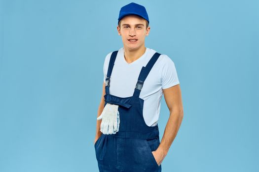 Working man in uniform of gloves loader rendering service blue background. High quality photo