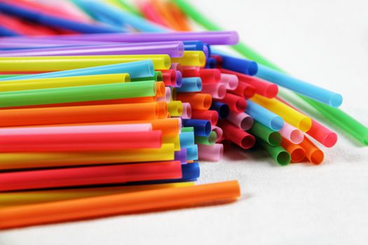 Colorful plastic drinking straws close up white background