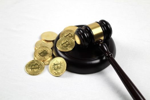 Golden bitcoins and judge gavel on white background