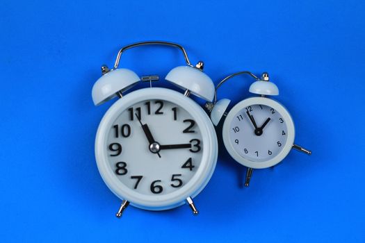 Clock marking winter time change in autumn blue background