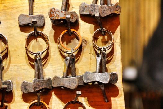 Ax-shaped forged metal keychains for sale at a medieval street market stall