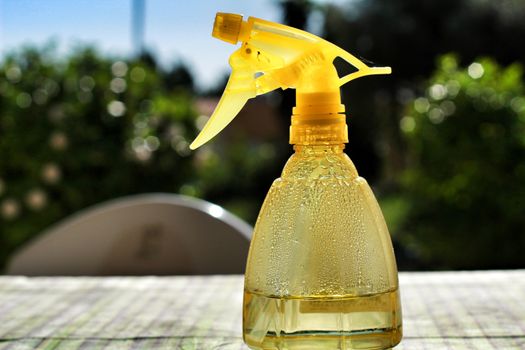 Yellow transparent atomizer with evaporated water under the sun