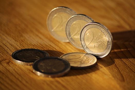 Two euro coins on brown wooden board