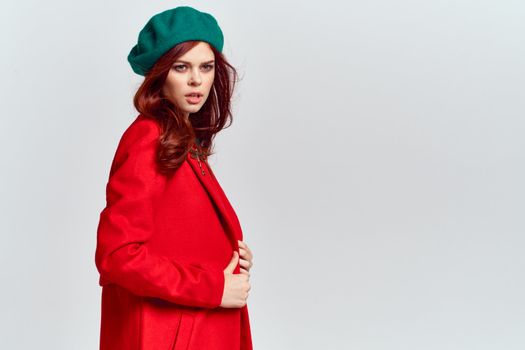 Woman in red coat and in green hat on isolated background cropped model with Copy Space emotions. High quality photo