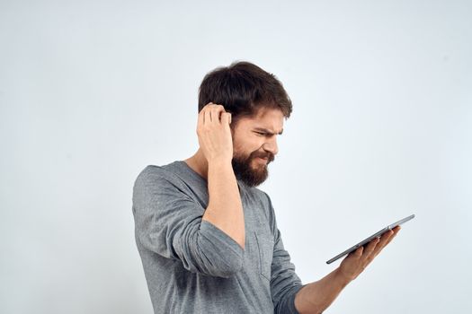 A man with a tablet in his hand internet technology communication gray jacket light background. High quality photo