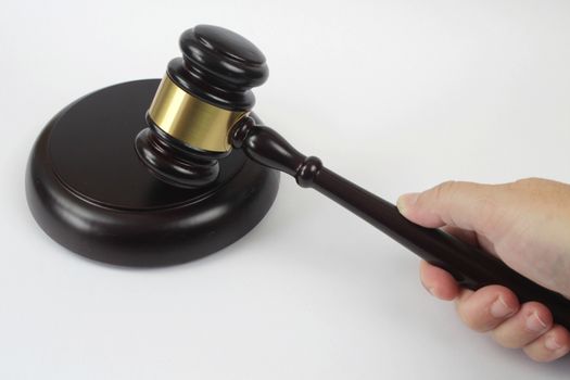 Hand holding a Wooden judge hammer on white background