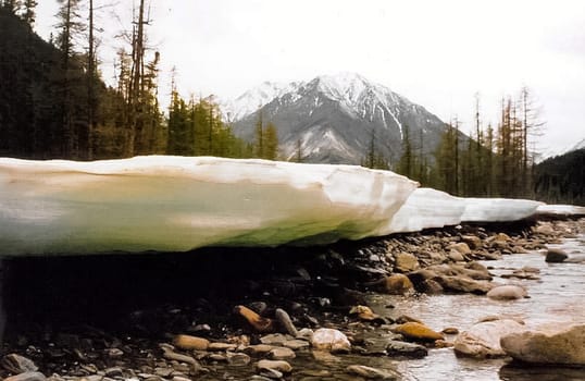 Ice and snow on the river. Melting snow in the spring on the reservoir.