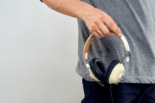 Man holding headphones in the hands of a man lifestyle modern style technology cropped view. High quality photo