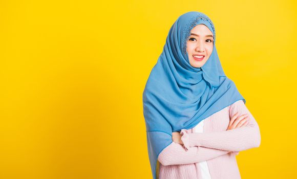 Asian Muslim Arab, Portrait of happy beautiful young woman religious wear veil hijab smiling she standing crossed arm studio shot isolated, yellow background with copy space, Close up skin face