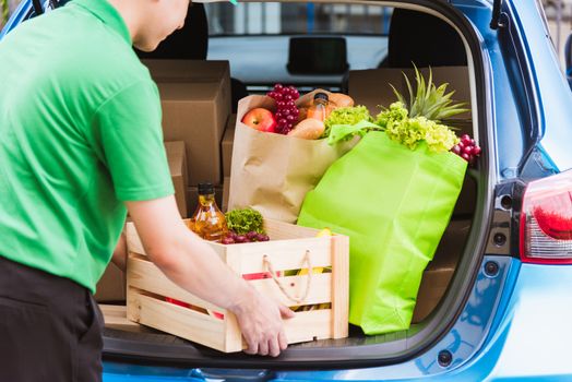 Asian delivery man grocery prepare service giving fresh vegetables food and fruit full in wooden basket on back car to send woman customer at door home after pandemic coronavirus, Back to new normal