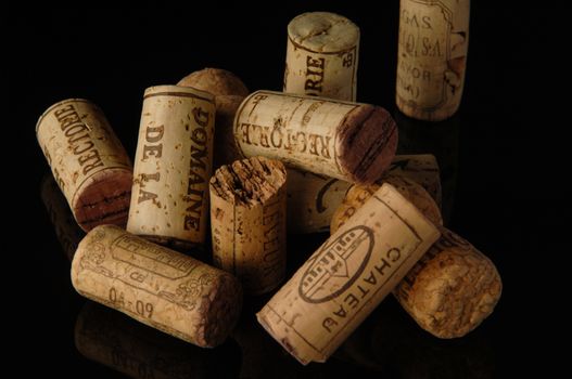 Tashkent, Uzbekistan - October 6, 2009 : Heap of old wine corks on black background with reflection. Studio photography