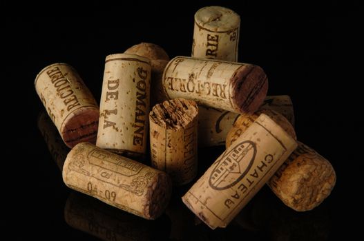 Tashkent, Uzbekistan - October 6, 2009 : Heap of old wine corks on black background with reflection. Studio photography