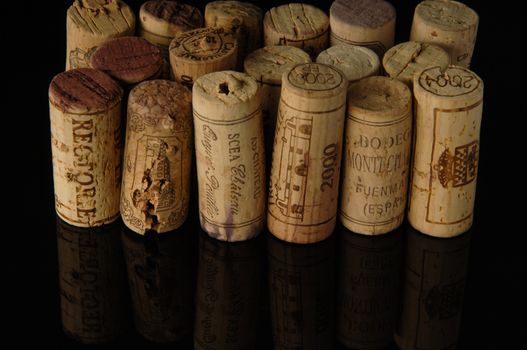 Tashkent, Uzbekistan - October 6, 2009 : Heap of old wine corks on black background with reflection. Studio photography