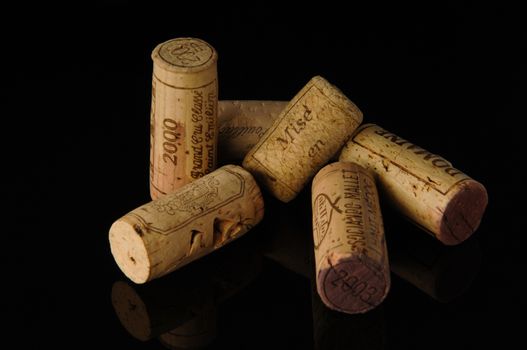 Tashkent, Uzbekistan - October 6, 2009 : Heap of old wine corks on black background with reflection. Studio photography