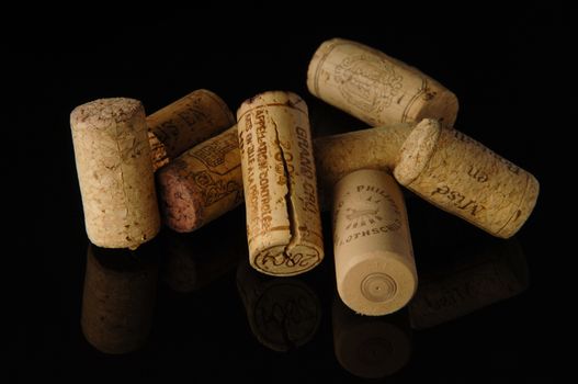 Tashkent, Uzbekistan - October 6, 2009 : Heap of old wine corks on black background with reflection. Studio photography
