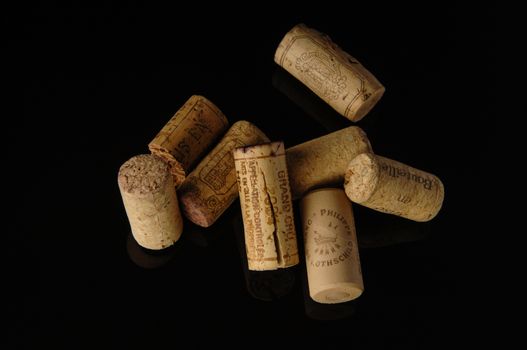Tashkent, Uzbekistan - October 6, 2009 : Heap of old wine corks on black background with reflection. Studio photography