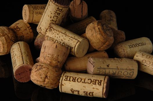 Tashkent, Uzbekistan - October 6, 2009 : Heap of old wine corks on black background with reflection. Studio photography