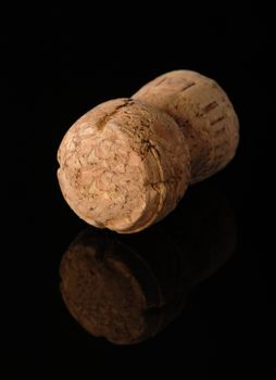 One old wine cork on black background with reflection