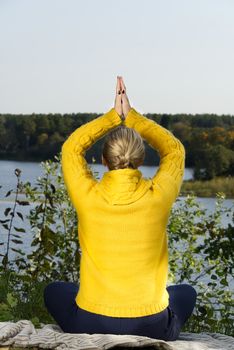 Beautiful young girl meditating in autumn park. woman meditates in the forest in sunny day.