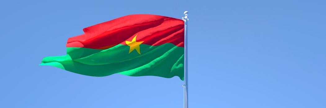 3D rendering of the national flag of Burkina Faso waving in the wind against a blue sky