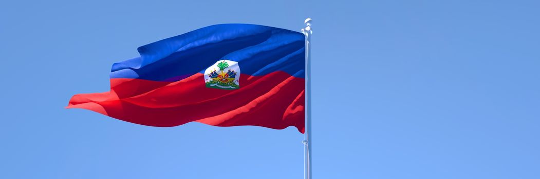 3D rendering of the national flag of Haiti waving in the wind against a blue sky