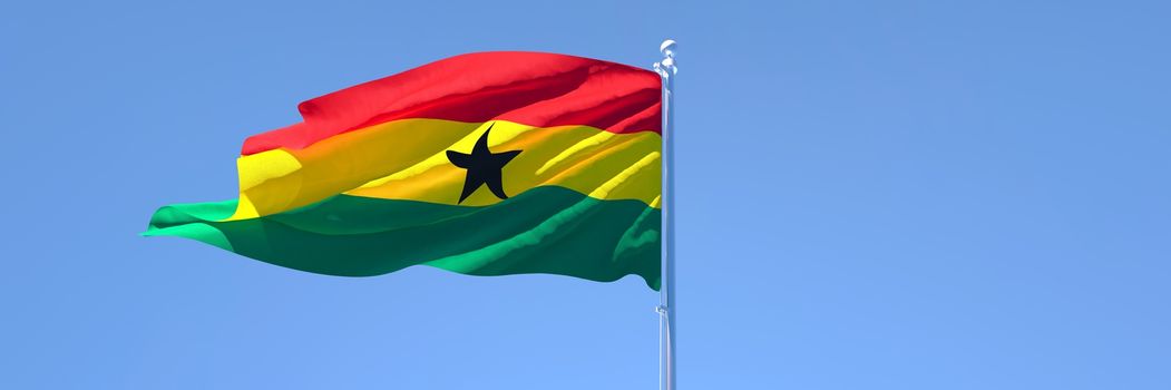 3D rendering of the national flag of Ghana waving in the wind against a blue sky