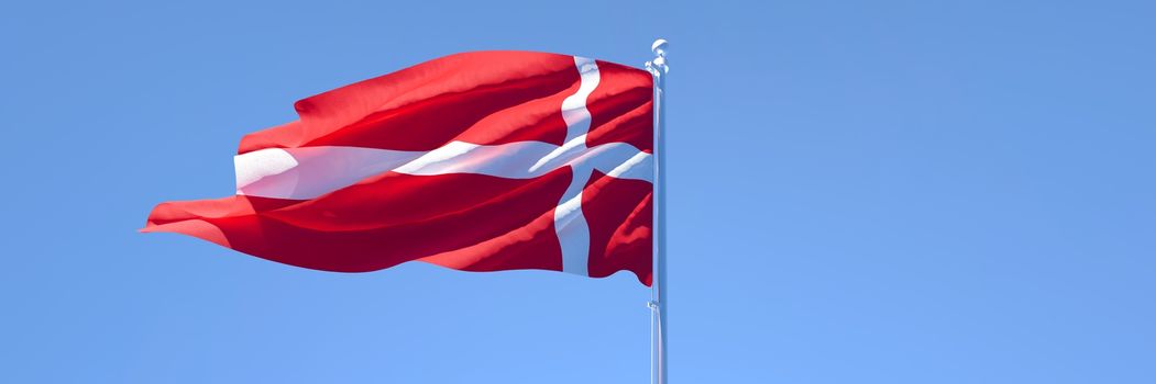 3D rendering of the national flag of Denmark waving in the wind against a blue sky