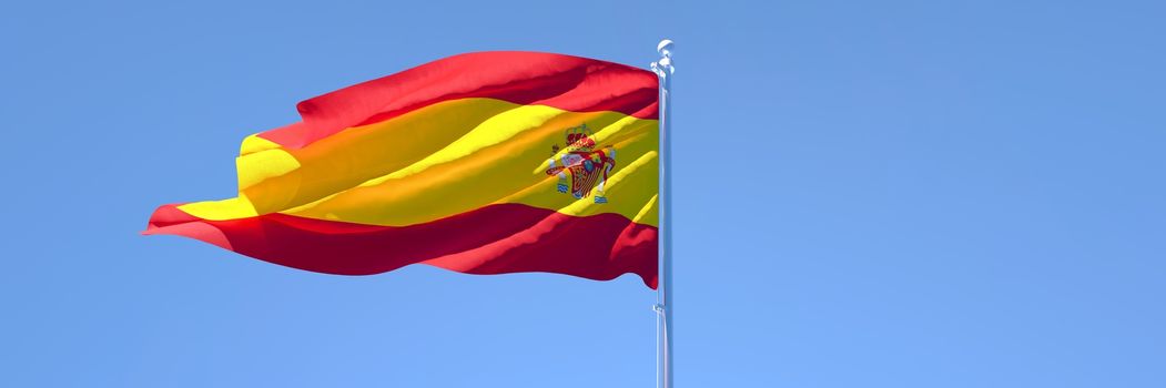 3D rendering of the national flag of Spain waving in the wind against a blue sky