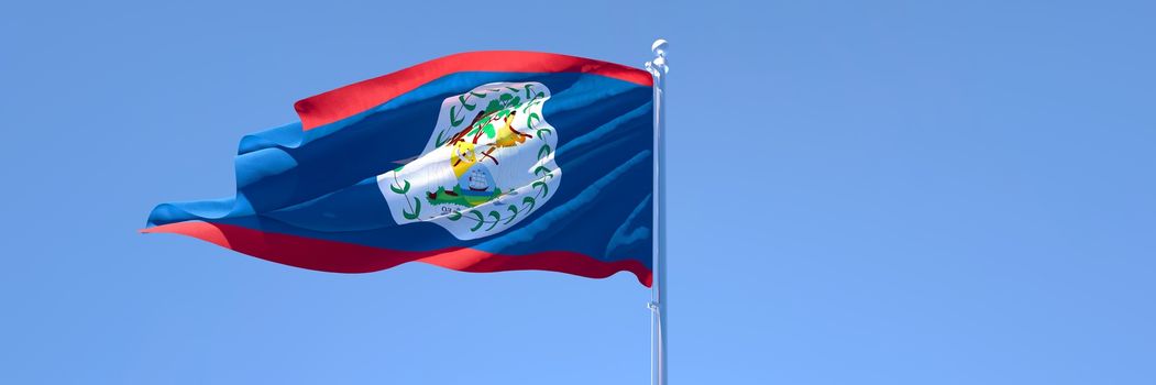 3D rendering of the national flag of Belize waving in the wind against a blue sky