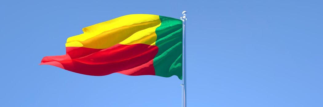 3D rendering of the national flag of Benin waving in the wind against a blue sky