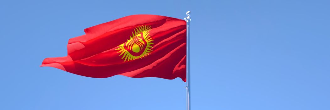 3D rendering of the national flag of Kyrgyzstan waving in the wind against a blue sky