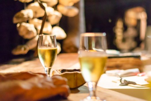 Glass of white wine on rustic bar counter.