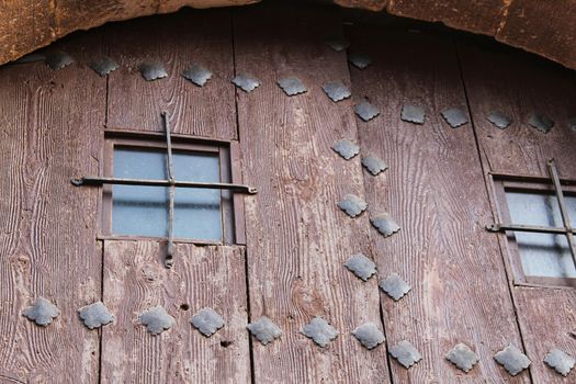 Old wooden door with wrought iron details in Villanueva de Los Infantes village, Spain