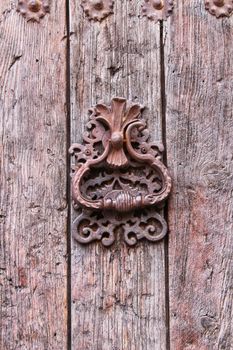 Vintage door knocker on old wooden door in Alcaraz, Spain
