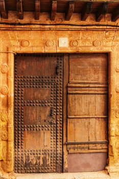 Old colorful carved wooden door with forged details in a small village in Castilla La Mancha community, Spain