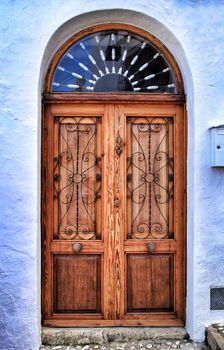 Old and colorful wooden door with iron details in Altea, Alicante, Spain