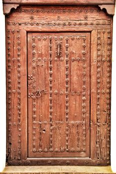 Old and colorful wooden door with iron details in Altea, Alicante, Spain