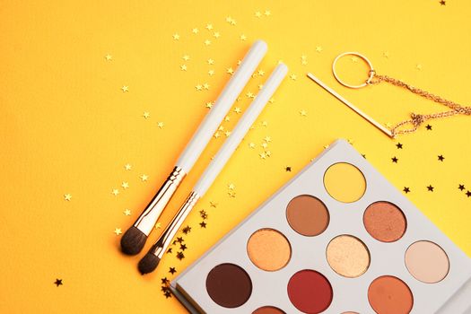 Professional eyeshadows and makeup brushes on a yellow background make-up decoration. High quality photo