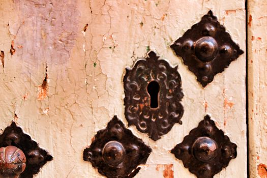 Old wooden door with wrought iron details in Xixona village, Alicante province, Spain.