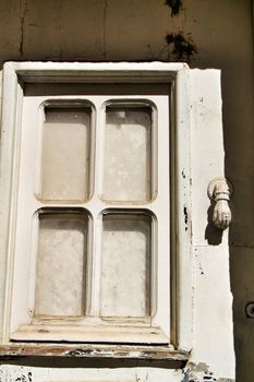 Doorknocker with hand shape on old white wooden door in Lisbon, Portugal